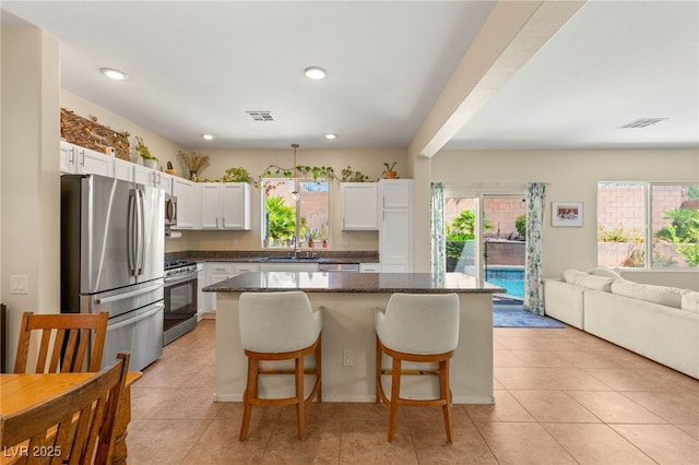 11226 Kenyan Sunshine Ct, Las Vegas, NV 89138 - kitchen with appliances with stainless steel finishes, open floor plan, a sink, white cabinets, and a center island