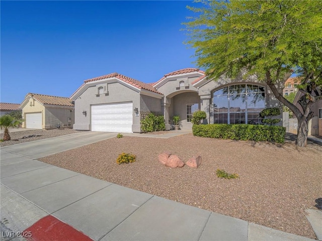 401 Obsidian St, Las Vegas, NV 89145 - mediterranean / spanish home featuring a tile roof, stucco siding, a garage, and driveway