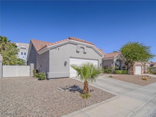 401 Obsidian St, Las Vegas, NV 89145 - mediterranean / spanish house featuring a tile roof, stucco siding, an attached garage, and concrete driveway