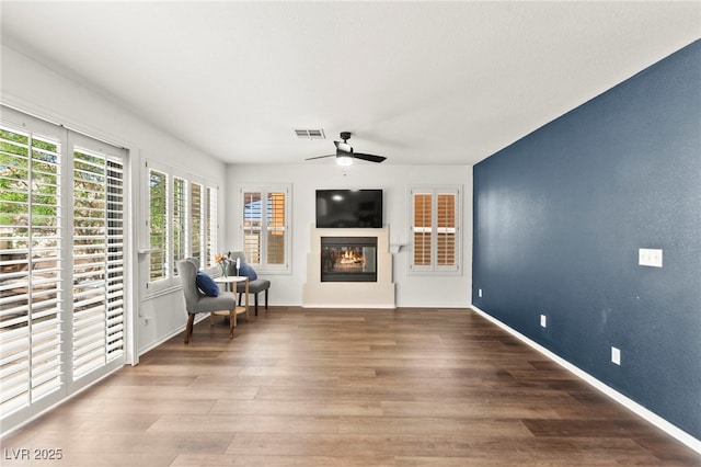 8612 Danza Del Sol Dr, Las Vegas, NV 89128 - living area featuring ceiling fan, a glass covered fireplace, plenty of natural light, and wood finished floors