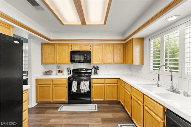 8612 Danza Del Sol Dr, Las Vegas, NV 89128 - kitchen featuring black appliances, a sink, dark wood-type flooring, and tile counters