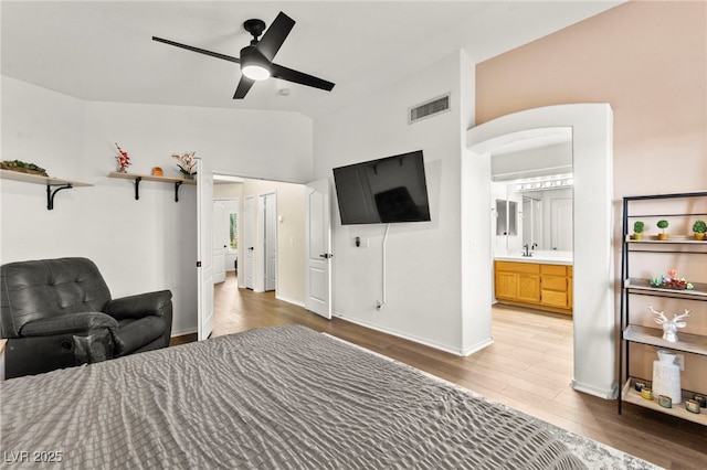8612 Danza Del Sol Dr, Las Vegas, NV 89128 - bedroom with wood finished floors, vaulted ceiling, baseboards, arched walkways, and a sink