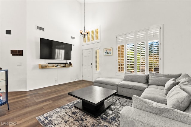 8612 Danza Del Sol Dr, Las Vegas, NV 89128 - living room with a chandelier, wood finished floors, a towering ceiling, and baseboards