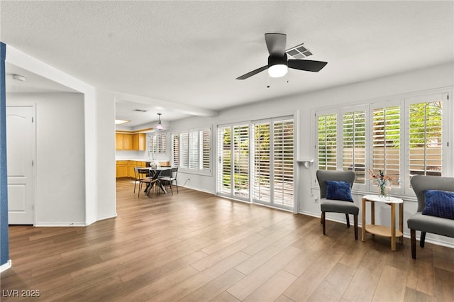 8612 Danza Del Sol Dr, Las Vegas, NV 89128 - sitting room with wood finished floors, a ceiling fan, baseboards, and a textured ceiling