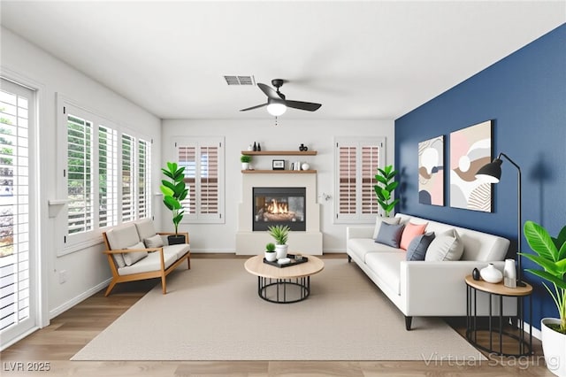 8612 Danza Del Sol Dr, Las Vegas, NV 89128 - living area featuring wood finished floors, ceiling fan, and a glass covered fireplace