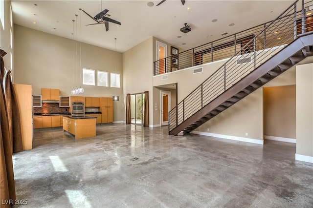1448 Canyon Ledge Ct, Las Vegas, NV 89117 - living area featuring a high ceiling, baseboards, finished concrete floors, stairway, and a ceiling fan