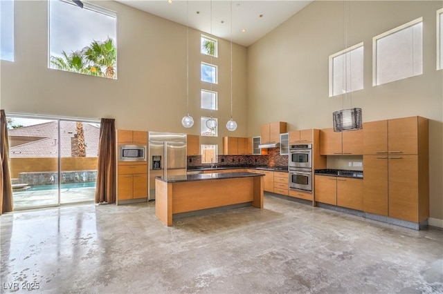 1448 Canyon Ledge Ct, Las Vegas, NV 89117 - kitchen with a high ceiling, built in appliances, concrete floors, dark countertops, and a kitchen island