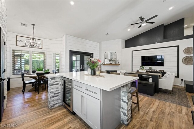 211 Kokopelli Ct, Henderson, NV 89074 - kitchen featuring beverage cooler, light wood finished floors, french doors, a center island, and a ceiling fan
