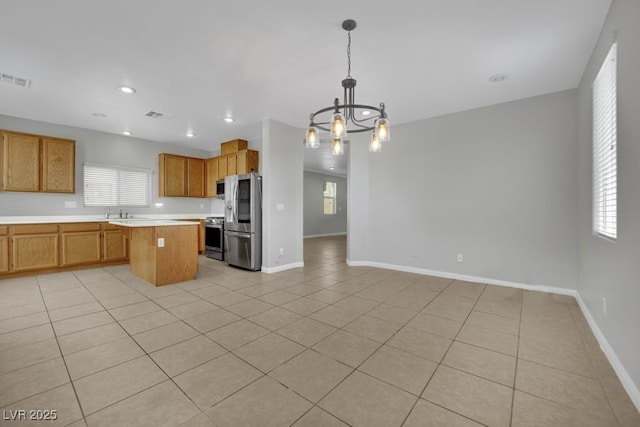 11787 Fern Creek Ln, Las Vegas, NV 89183 - kitchen featuring stainless steel appliances, a chandelier, a kitchen island, light countertops, and healthy amount of natural light