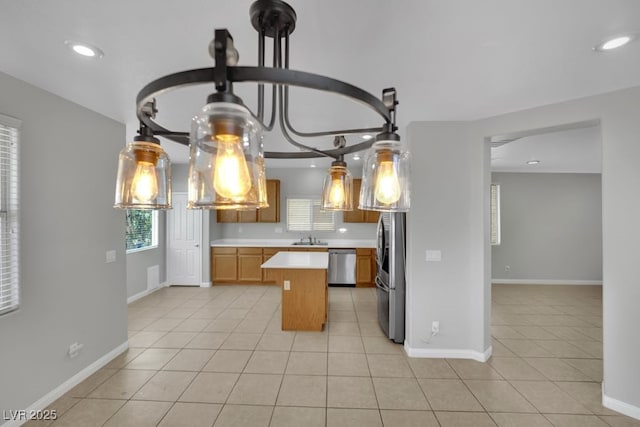 11787 Fern Creek Ln, Las Vegas, NV 89183 - kitchen with appliances with stainless steel finishes, a sink, light countertops, light tile patterned floors, and a kitchen island