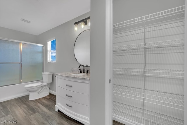 11787 Fern Creek Ln, Las Vegas, NV 89183 - bathroom with toilet, vanity, wood finished floors, enclosed tub / shower combo, and baseboards