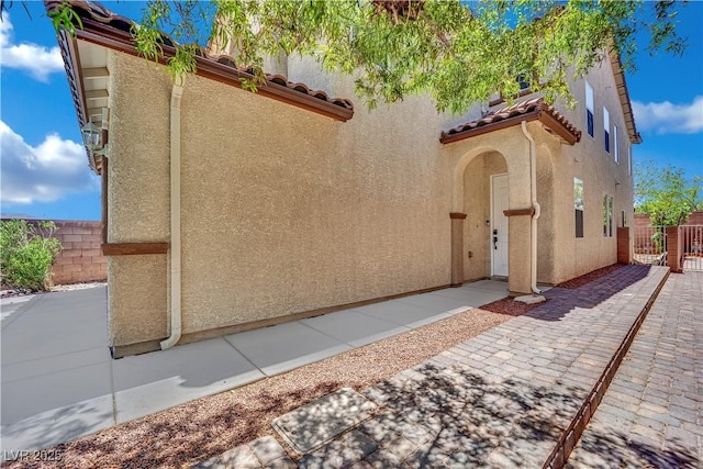 11787 Fern Creek Ln, Las Vegas, NV 89183 - property entrance with stucco siding, a gate, a tiled roof, and a patio