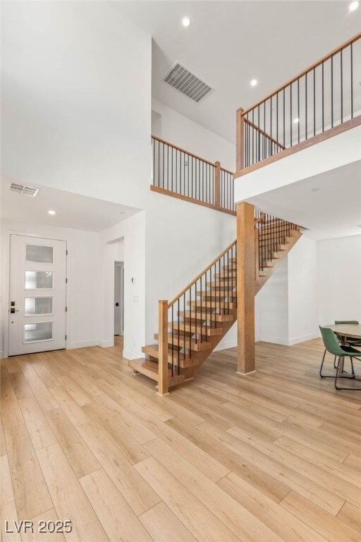2578 Skylark Trail St, Henderson, NV 89044 - unfurnished living room with a towering ceiling, hardwood / wood-style flooring, stairway, recessed lighting, and baseboards