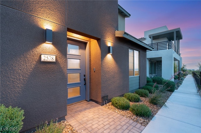 2578 Skylark Trail St, Henderson, NV 89044 - exterior entry at dusk featuring stucco siding and a balcony