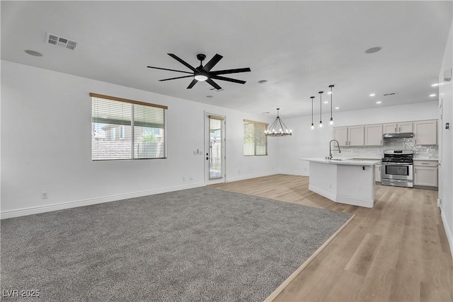 576 Foster Springs Rd, Las Vegas, NV 89148 - unfurnished living room featuring healthy amount of natural light, a ceiling fan, a chandelier, a sink, and recessed lighting