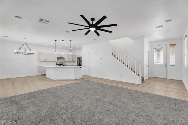 576 Foster Springs Rd, Las Vegas, NV 89148 - unfurnished living room with light wood-style floors, stairs, recessed lighting, a chandelier, and baseboards