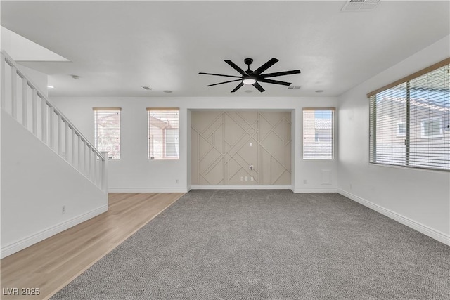 576 Foster Springs Rd, Las Vegas, NV 89148 - unfurnished living room with a ceiling fan, stairs, baseboards, light colored carpet, and light wood-style floors