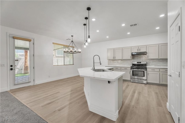 576 Foster Springs Rd, Las Vegas, NV 89148 - kitchen with stainless steel gas range oven, a sink, under cabinet range hood, light countertops, and decorative backsplash