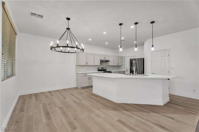 576 Foster Springs Rd, Las Vegas, NV 89148 - kitchen featuring appliances with stainless steel finishes, light wood-type flooring, light countertops, a chandelier, and baseboards