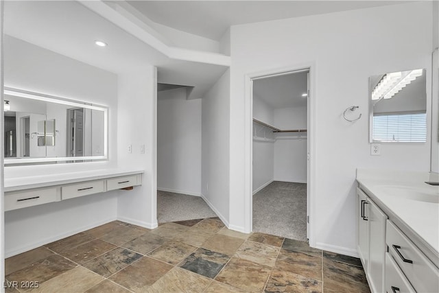 576 Foster Springs Rd, Las Vegas, NV 89148 - bathroom with vanity, a walk in closet, stone finish flooring, and baseboards
