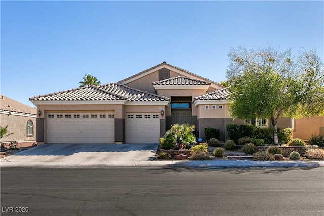 2713 Tanagrine Dr, North Las Vegas, NV 89084 - mediterranean / spanish home with stucco siding, a garage, concrete driveway, and a tiled roof