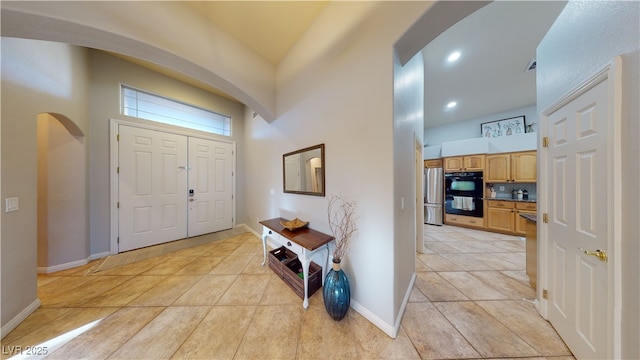 2713 Tanagrine Dr, North Las Vegas, NV 89084 - foyer entrance featuring arched walkways, light tile patterned floors, baseboards, a towering ceiling, and recessed lighting