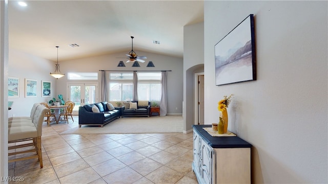 2713 Tanagrine Dr, North Las Vegas, NV 89084 - living room with vaulted ceiling, arched walkways, ceiling fan, light tile patterned floors, and light carpet