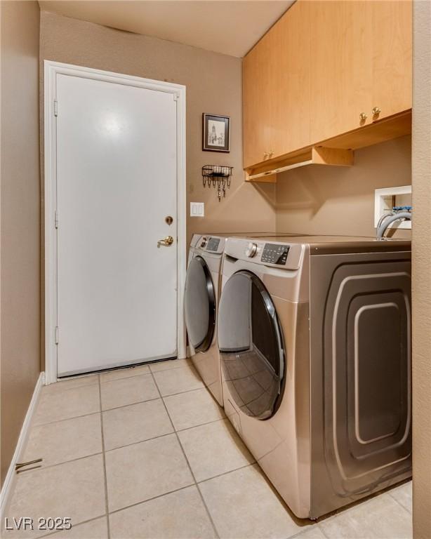 3088 Paseo Mountain Ave, Henderson, NV 89052 - laundry area featuring cabinet space, light tile patterned flooring, and washer and dryer