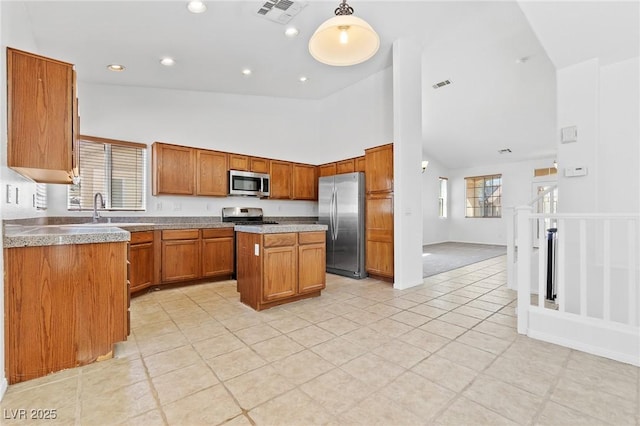 3273 Alcudia Bay Ave, Las Vegas, NV 89141 - kitchen featuring stainless steel appliances, high vaulted ceiling, light tile patterned floors, brown cabinets, and a kitchen island