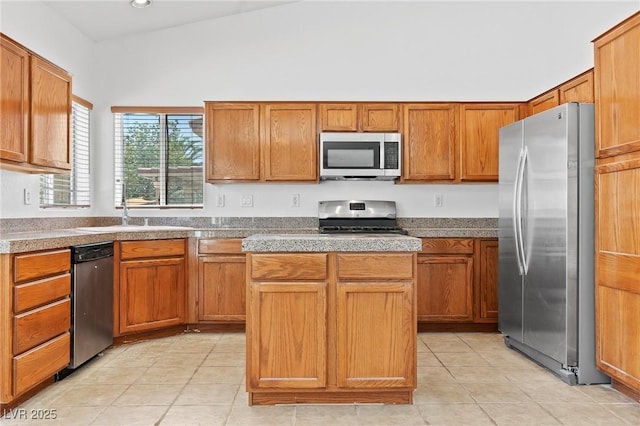 3273 Alcudia Bay Ave, Las Vegas, NV 89141 - kitchen featuring stainless steel appliances, light tile patterned flooring, a kitchen island, brown cabinetry, and a sink