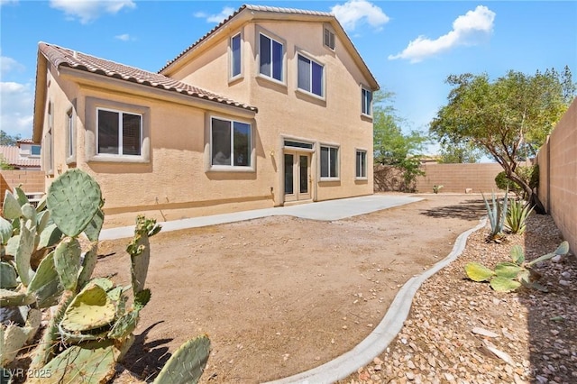 3273 Alcudia Bay Ave, Las Vegas, NV 89141 - back of house featuring a tile roof, a fenced backyard, stucco siding, and a patio area