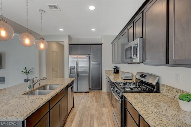 5244 Fiery Sky Ridge St, Las Vegas, NV 89148 - kitchen with stainless steel appliances, a sink, light wood-style floors, light stone counters, and recessed lighting