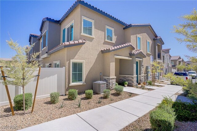 7350 N Decatur Blvd Unit 5, Las Vegas, NV 89131 - mediterranean / spanish-style house featuring a tile roof, cooling unit, and stucco siding
