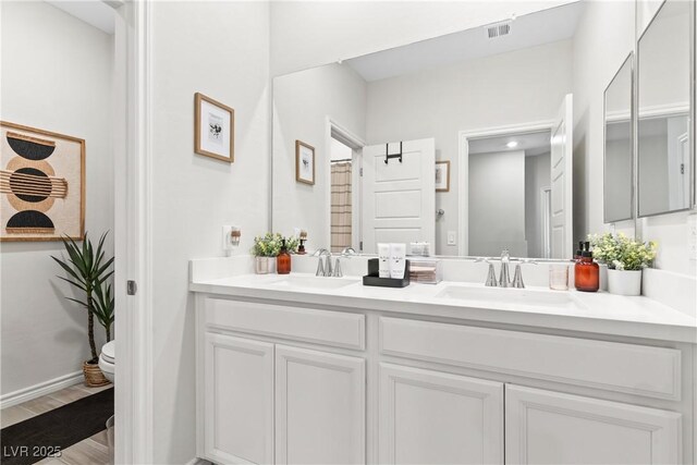 7350 N Decatur Blvd Unit 5, Las Vegas, NV 89131 - bathroom featuring double vanity, toilet, and wood finished floors