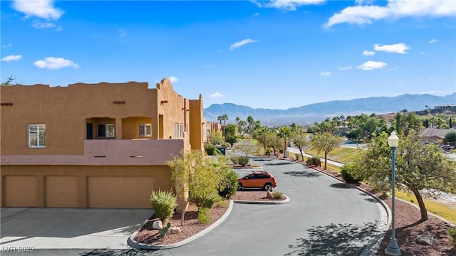 728 Hardy Way Unit E, Mesquite, NV 89027 - view of community with a mountain view, concrete driveway, and an attached garage