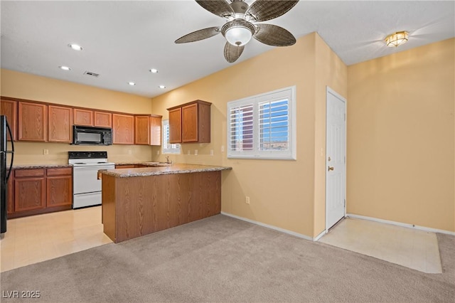 728 Hardy Way Unit E, Mesquite, NV 89027 - kitchen with black appliances, light carpet, a peninsula, brown cabinetry, and recessed lighting