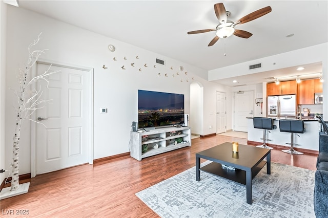 200 W Sahara Ave Unit 3303, Las Vegas, NV 89102 - living room with arched walkways, ceiling fan, light wood-style floors, and baseboards