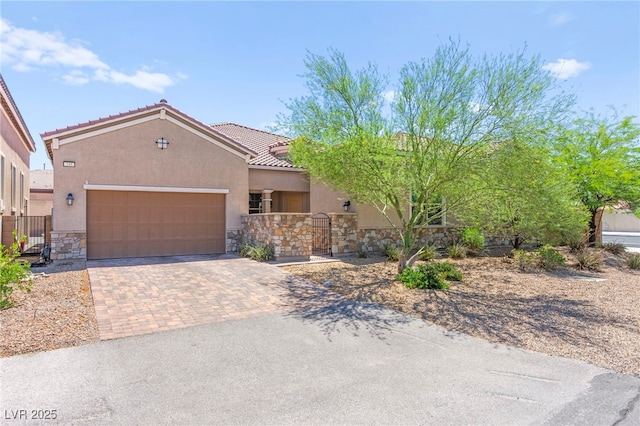 245 Hull St, Henderson, NV 89015 - view of front of house featuring stone siding, an attached garage, a gate, and stucco siding