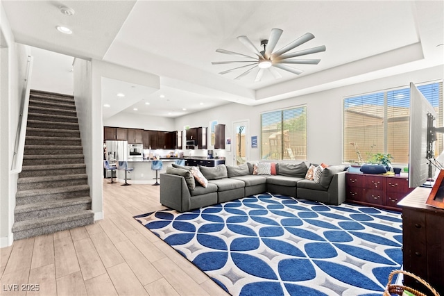 245 Hull St, Henderson, NV 89015 - living room featuring a raised ceiling, ceiling fan, light wood finished floors, stairway, and recessed lighting