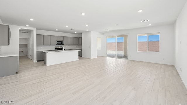 4450 E Brusca Ct, Pahrump, NV 89061 - kitchen with appliances with stainless steel finishes, gray cabinets, open floor plan, recessed lighting, and backsplash