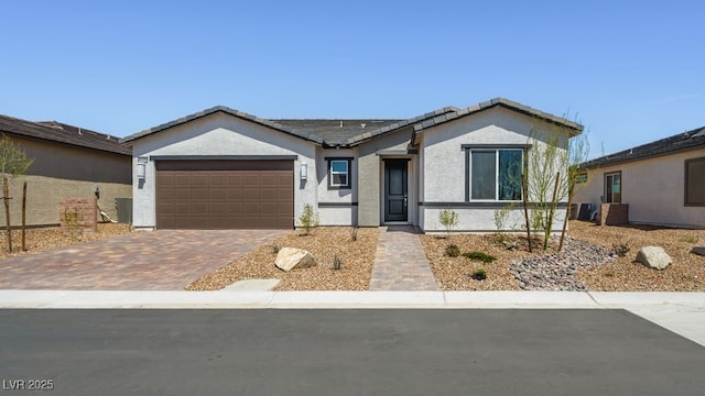 4450 E Brusca Ct, Pahrump, NV 89061 - ranch-style house with decorative driveway, a garage, stucco siding, and a tile roof