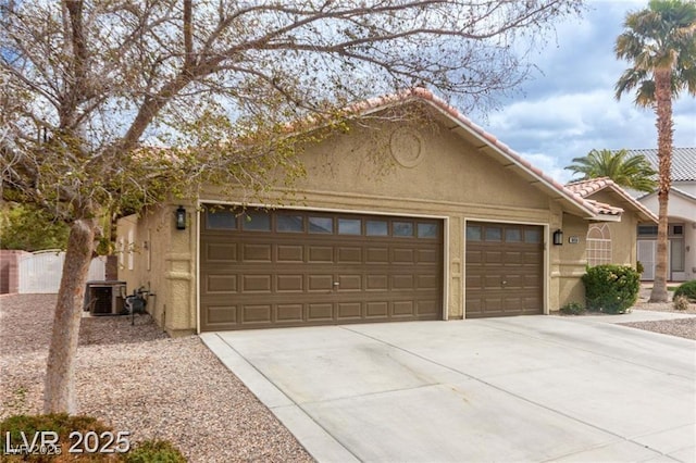 10058 Saint Augustine St, Las Vegas, NV 89183 - view of front of house featuring a garage, stucco siding, driveway, cooling unit, and a tile roof