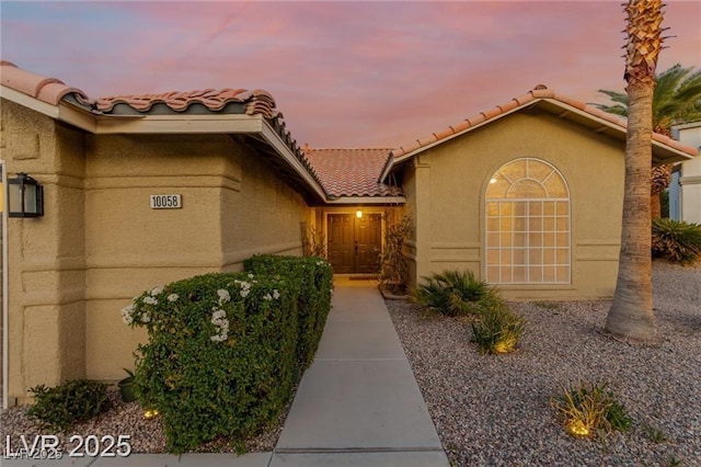 10058 Saint Augustine St, Las Vegas, NV 89183 - property entrance with a tile roof and stucco siding