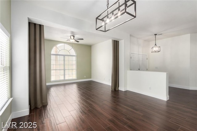 10058 Saint Augustine St, Las Vegas, NV 89183 - unfurnished living room with plenty of natural light, a chandelier, baseboards, and dark wood-style floors