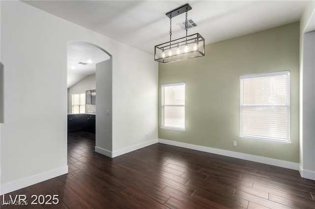10058 Saint Augustine St, Las Vegas, NV 89183 - unfurnished room featuring arched walkways, dark wood-type flooring, baseboards, and vaulted ceiling