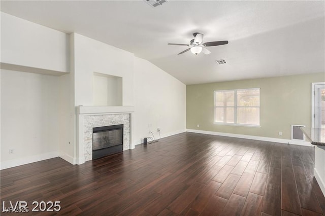 10058 Saint Augustine St, Las Vegas, NV 89183 - unfurnished living room featuring lofted ceiling, plenty of natural light, ceiling fan, a stone fireplace, and dark wood-style flooring