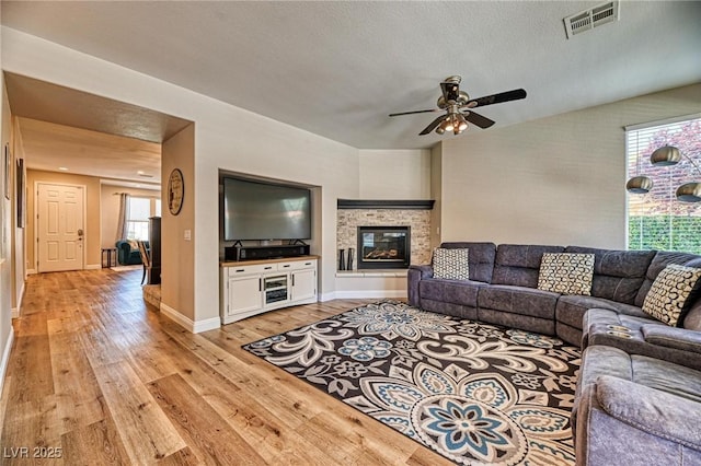 2285 Moresca Ave, Henderson, NV 89052 - living room with light wood-style floors, a ceiling fan, baseboards, and a glass covered fireplace
