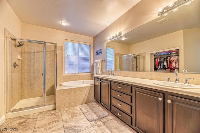 2285 Moresca Ave, Henderson, NV 89052 - bathroom featuring a bath, a shower stall, double vanity, and a spacious closet