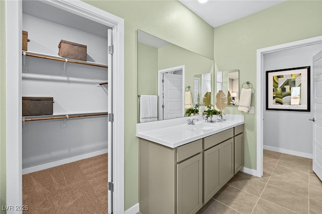 4365 E Brusca Way, Pahrump, NV 89061 - bathroom with double vanity, baseboards, a walk in closet, and tile patterned floors