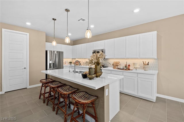 4365 E Murlo Rd, Pahrump, NV 89061 - kitchen featuring stainless steel appliances, a breakfast bar, decorative backsplash, light countertops, and white cabinetry